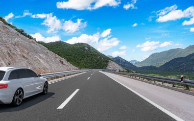 Araba otoban boyunca sürüyor. Etrafı resimlerle çevrili..