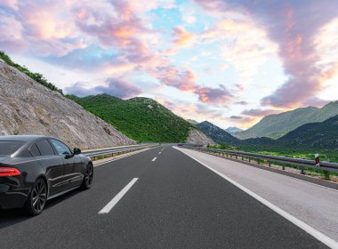 Araba otoban boyunca sürüyor. Etrafı resimlerle çevrili..