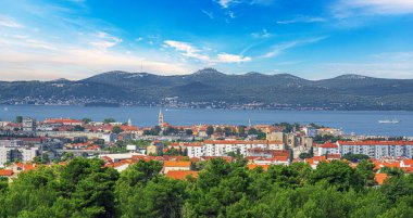 Hırvatistan 'ın Zadar kentinin çarpıcı panoramik manzarası, ikonik kırmızı çatıları, modern ve tarihi mimarisi ve Adriyatik Denizi ve uzak dağların nefes kesici zeminini gözler önüne seriyor.