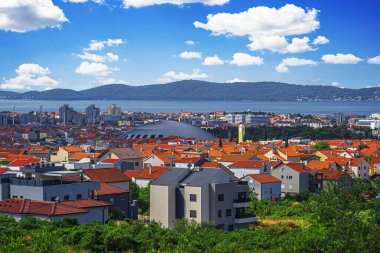 Hırvatistan 'ın Zadar kentinin çarpıcı panoramik manzarası, ikonik kırmızı çatıları, modern ve tarihi mimarisi ve Adriyatik Denizi ve uzak dağların nefes kesici zeminini gözler önüne seriyor.