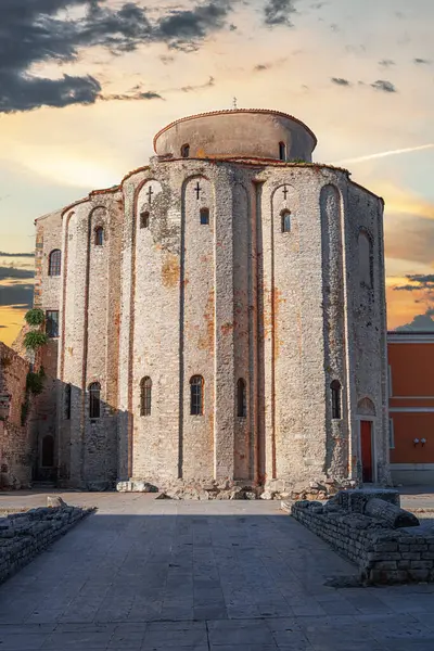 Hırvatistan 'ın tarihi eski Zadar kasabasında, gün batımında St. Anastasia Katedrali' nin çan kulesi ve St. Donatus Kilisesi 'nin çarpıcı manzarası.