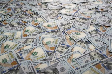 Yüz dolarlık kaotik banknotlar çerçeveyi dolduruyor, finansal bolluğu, para akışını ve ekonomik gücü sembolize eden dokulu bir arka plan oluşturuyor..