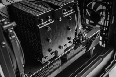 Yüksek performanslı bir CPU soğutucusunun yakın çekim görüntüsü, örgülü güç kabloları ve özel yapım bir masaüstü bilgisayarı içinde soğutma yüzgeçleri.