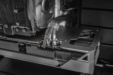Yüksek performanslı bir CPU soğutucusunun yakın çekim görüntüsü, örgülü güç kabloları ve özel yapım bir masaüstü bilgisayarı içinde soğutma yüzgeçleri.