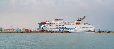 Split, Hırvatistan - 25 Temmuz 2023: Hırvatistan 'ın Split limanına yanaşan büyük feribot, çevresindeki kargo kamyonları ve kıyı tepeleri ve şehir binaları manzaralı bir zemin hazırladı.