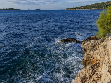 Okyanus dalgaları güçlü ve dinamik bir köpüklü beyaz su ve doğal kuvvet gösterisi oluşturan kayalık bir uçuruma enerjiyle çarpar..