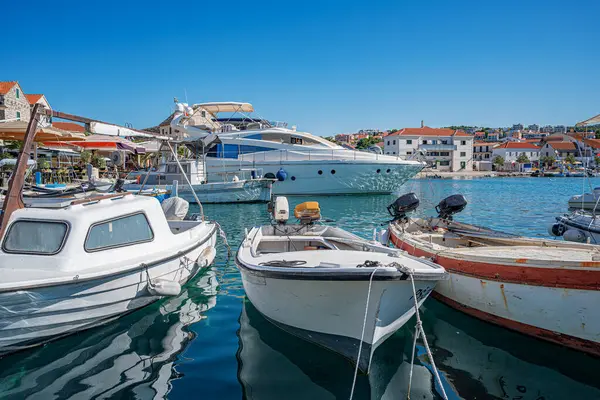 Birçok lüks yat ve tekne, sakin deniz ve uzak yeşil kıyı şeridi ile çevrili güneşli bir marinada demirlemiştir.