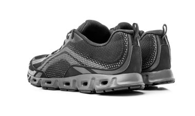 Beyaz arka planda izole edilmiş, nefes alınabilir bir tasarım sunan ve ideal performans ve konfor için yastıklı bir çift modern siyah ağlı spor ayakkabı..