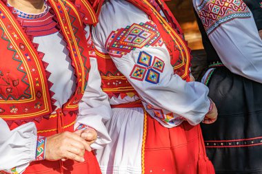 Canlı bir açık hava kültür festivali sırasında karmaşık nakış işlemeli renkli geleneksel Doğu Avrupa halk kıyafetleri giyiliyor.