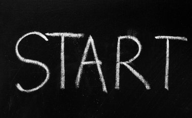 Siyah bir karatahtaya beyaz tebeşirle yazılmış START sözcüğünün yakın plan çekimi, yeni başlangıçları ya da eylem çağrısını sembolize ediyor.
