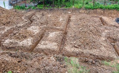 Bir inşaat temeli için çukur kazılmış kahverengi toprak, yukarıdan bakıldığında.