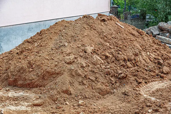 Büyük bir toprak yığını ve küçük kayalar dış inşaat sahasında peyzaj veya inşaat projeleri için hazır bekliyor..