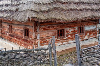 Köy mirası köyünde dokuma ahşap çitlerle çevrili sazdan çatılı ve küçük pencereli geleneksel ahşap kulübe..