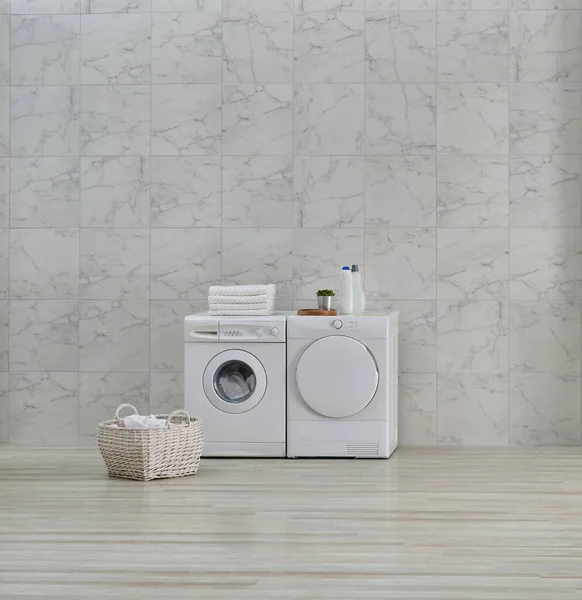 Washing machine and bathroom cabinet sink mirror style, white ceramic wall background.