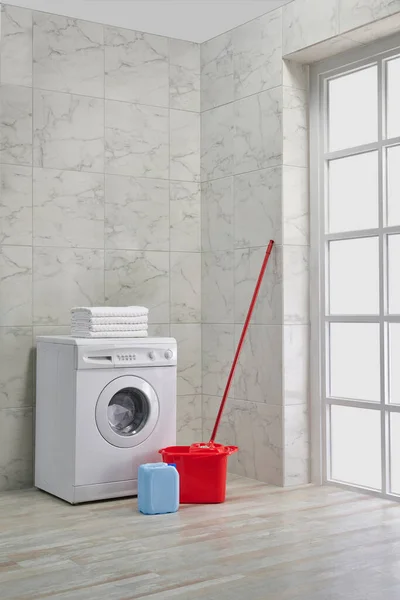 Washing machine in the bath room, cleaning kits, corner style, decorative object, towel, brush, dirty clothes.