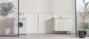 Washing machine in the bathroom, white brick wall background, vase of plant, cabinet and marble floor, folding screen.