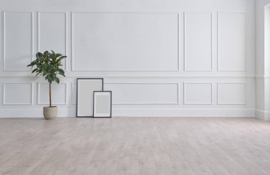 White classic wall background, brown parquet floor, home furniture detail, frame and vase of plant.