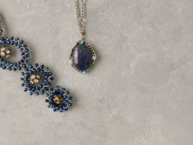 Elegant jewelry set ring, necklace and earrings with diamonds.Product still life concept. Modern and decorative textured background.