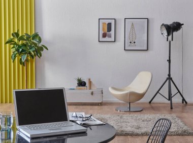 Gri taş duvar arkaplanı, ev tasarımı, iç dekorasyon, kanepe sallanan sandalye, çerçeve lambası ve dolap, masa ve dizüstü bilgisayarı kapat.