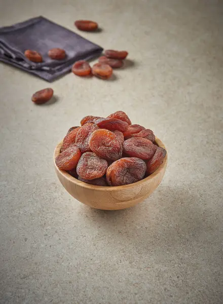 Delicious dried apricots and dry fruits on the background, close up style, in the plate still life.