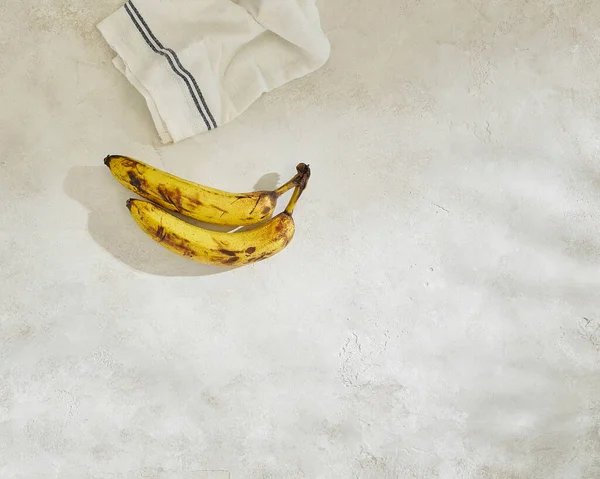 Bananas Estão Mesa Concreto Cinza Close Branco Azul Guardanapo Fundo — Fotografia de Stock