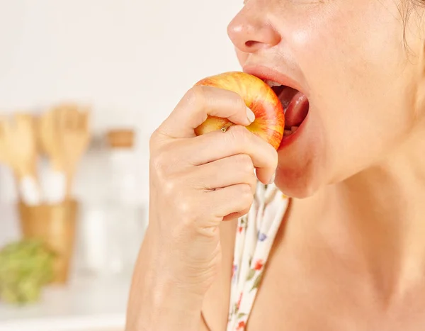 リンゴ クローズアップ 手を食べている女性 キッチンバックスタイル — ストック写真
