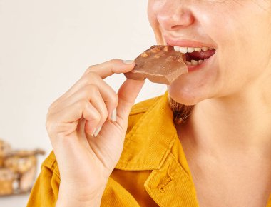 Çikolata yiyen kadın, yakın plan, el ve ağız..
