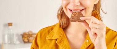 Çikolata yiyen kadın, yakın plan, el ve ağız..