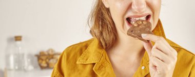 Çikolata yiyen kadın, yakın plan, el ve ağız..