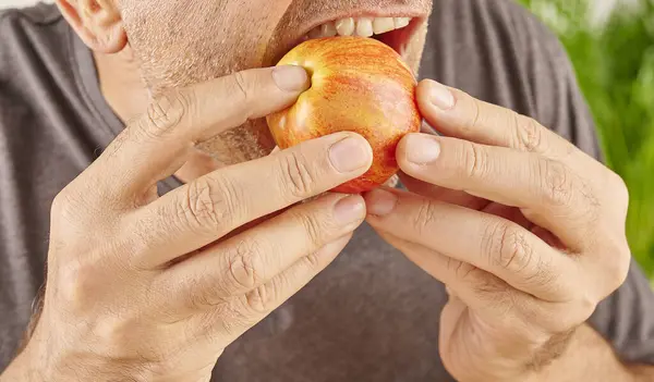 Zamknij Usta Człowieka Jedzącego Czerwone Jabłko Tło Kuchni — Zdjęcie stockowe