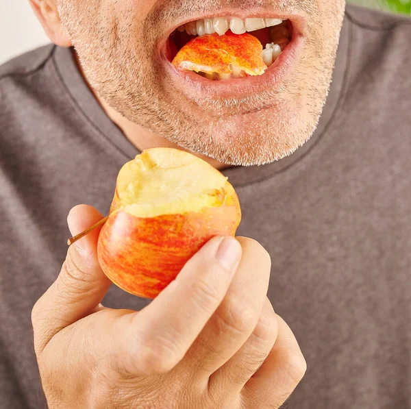 Zamknij Usta Człowieka Jedzącego Czerwone Jabłko Tło Kuchni — Zdjęcie stockowe