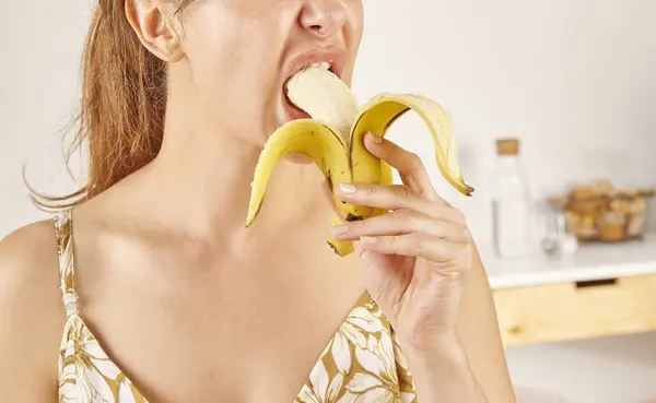 Mulher Comendo Banana Close Mão Boca Fundo Cozinha — Fotografia de Stock