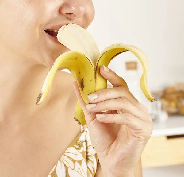 Mulher Comendo Banana Close Mão Boca Fundo Cozinha — Fotografia de Stock