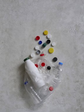 Plastik şişeler ve kapaklar yeşil masada, atık konseptini geri dönüştürüyorlar..