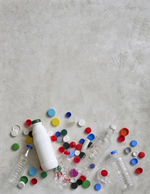 Plastik şişeler ve kapaklar yeşil masada, atık konseptini geri dönüştürüyorlar..