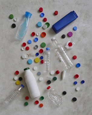 Plastik şişeler ve kapaklar yeşil masada, atık konseptini geri dönüştürüyorlar..