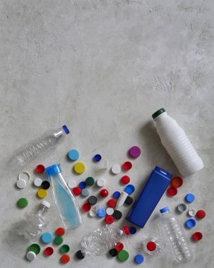 Plastik şişeler ve kapaklar yeşil masada, atık konseptini geri dönüştürüyorlar..
