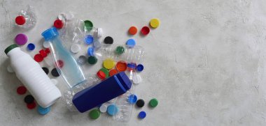 Plastik şişeler ve kapaklar yeşil masada, atık konseptini geri dönüştürüyorlar..