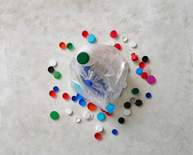 Plastik şişeler ve kapaklar yeşil masada, atık konseptini geri dönüştürüyorlar..