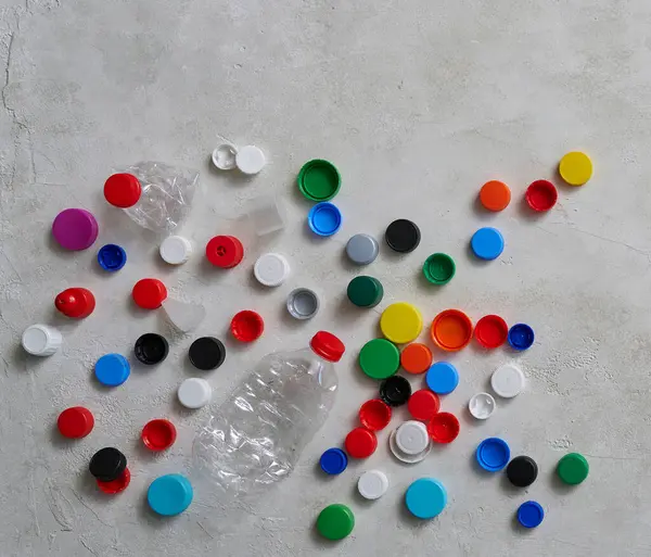 Plastik Şişeler Kapaklar Yeşil Masada Atık Konseptini Geri Dönüştürüyorlar — Stok fotoğraf