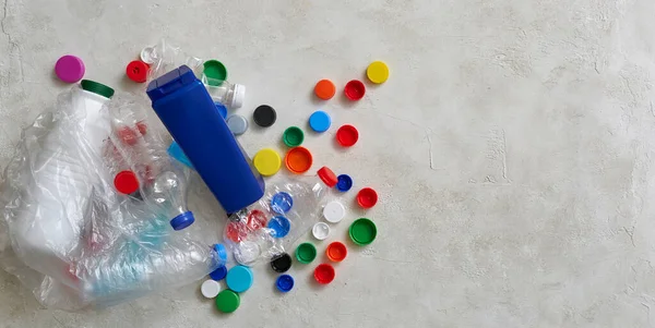 Plastic bottles and caps are on the green table, recycling waste concept.