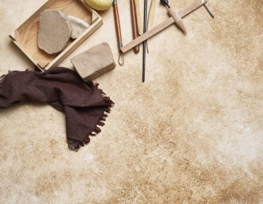 Dekoratif masa arka planında seramik, kadın eli ve araçlar yapmak, yukarı görünüm.