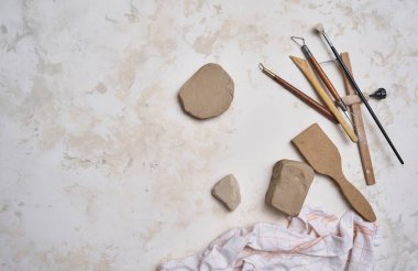 Dekoratif masa arka planında seramik, kadın eli ve araçlar yapmak, yukarı görünüm.