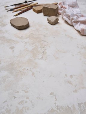 Dekoratif masa arka planında seramik, kadın eli ve araçlar yapmak, yukarı görünüm.