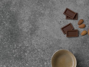 Seramik cam kahve stili, arka planda çikolata ve badem, gri dekoratif tasarım..