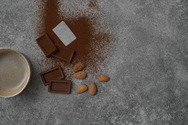 Seramik cam kahve stili, arka planda çikolata ve badem, gri dekoratif tasarım..