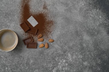 Seramik cam kahve stili, arka planda çikolata ve badem, gri dekoratif tasarım..