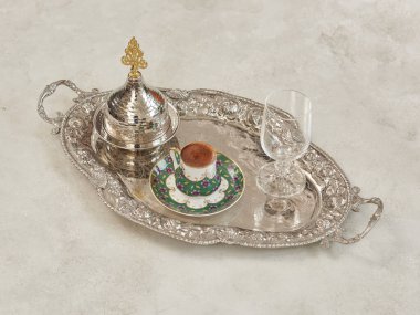 Gümüş tepsi, fincan ve şeker kasesi gri masa tarzında..