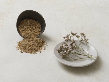 Dekoratif masa stilinde nane ve kekik gibi çeşitli otlar, kaşık, fincan ve tabaklar, sağlıklı yiyecekler..