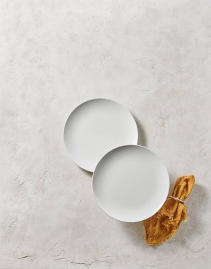 Beyaz boş tabak, dekoratif desenli peçete. Yukarı görünüm.